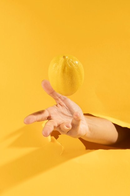 Close-up mano atrapar limón crudo