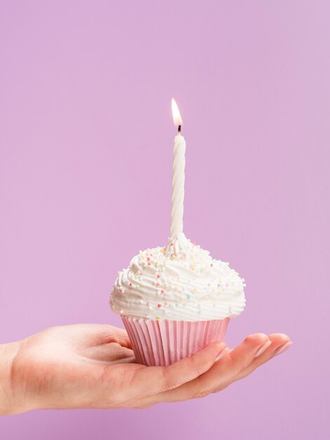 Close-up mano sosteniendo muffin de cumpleaños