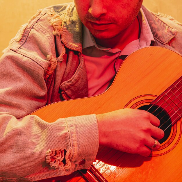 Close-up mano tocando la guitarra acústica