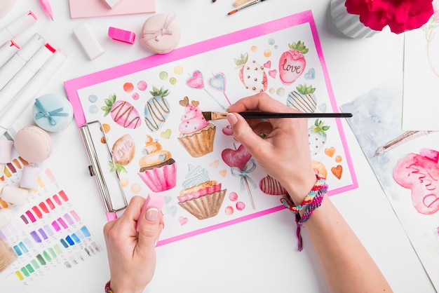 Close-up manos pintando cupcake