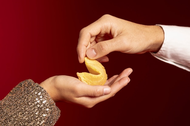 Close-up de manos sosteniendo la galleta de la fortuna para el año nuevo chino
