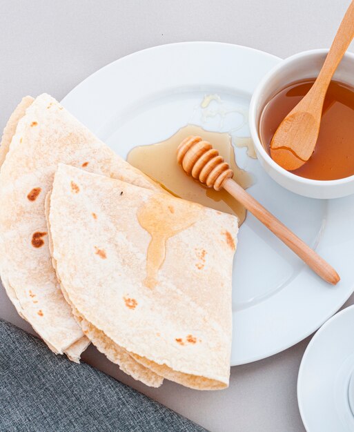 Close-up miel y tortillas en un plato