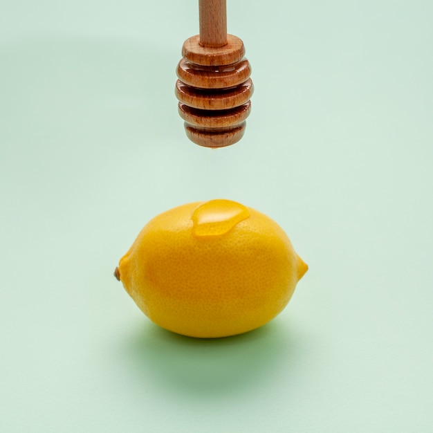 Close-up miel vertiendo sobre un limón
