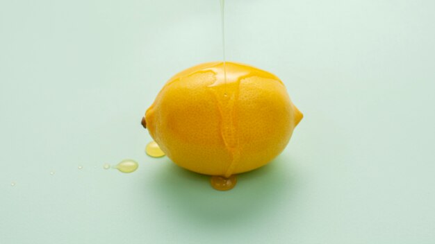 Close-up miel vertiendo sobre un limón