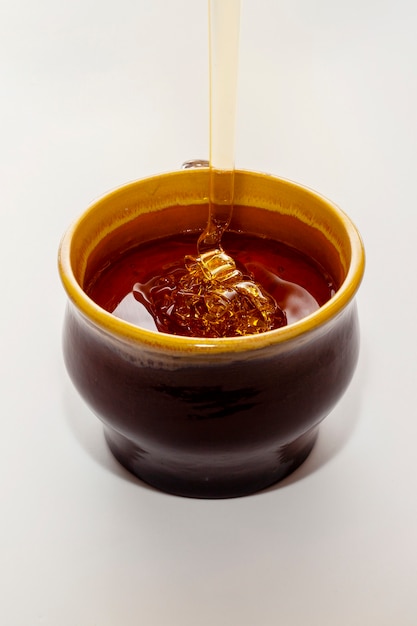 Close-up miel vertiendo en un tazón