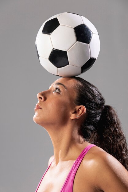 Close-up mujer adulta sosteniendo la bola en la cabeza