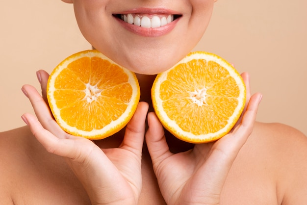 Foto gratuita close-up mujer asiática con amplia sonrisa y naranja