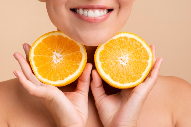 Close-up mujer asiática con amplia sonrisa y naranja