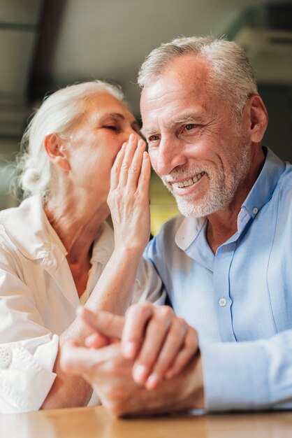 Close-up mujer diciendo a hombre un secreto