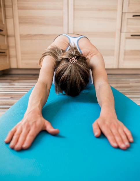 Foto gratuita close-up mujer estirando sobre estera de yoga