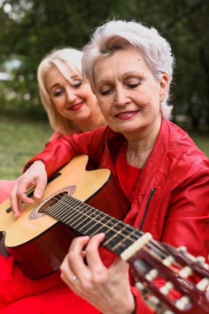 Close-up mujer senior tocando la guitarra