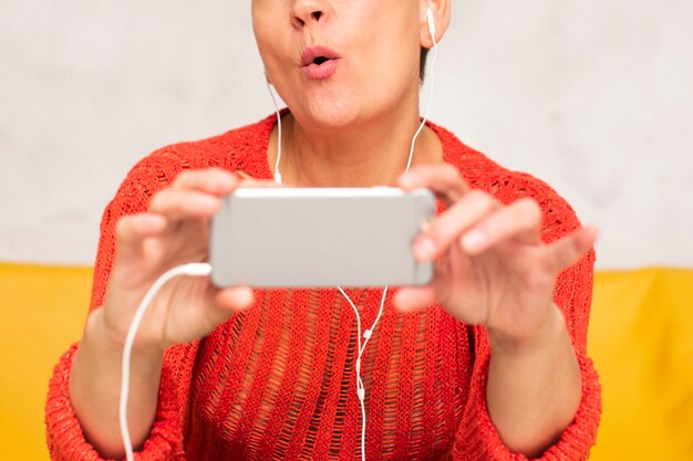 Close-up mujer senior viendo videos musicales