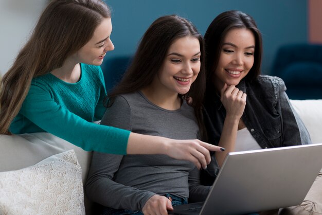 Close-up mujeres adultas navegando juntas por una computadora portátil