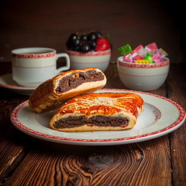 Close-up panadería casera con taza de té, dulces y bayas en la mesa de madera