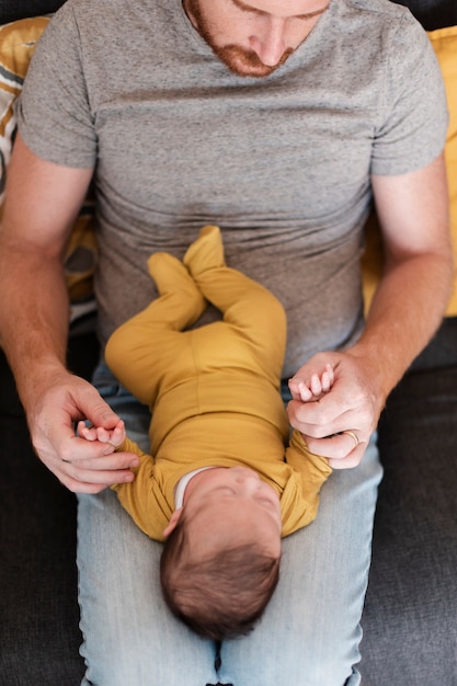 Foto gratuita close-up papá con bebé en sus piernas