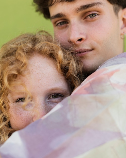 Foto gratuita close-up pareja abrazándose con fondo verde