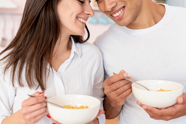Close-up pareja feliz con cereales y leche