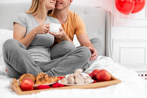 Close-up pareja feliz con desayuno en la cama