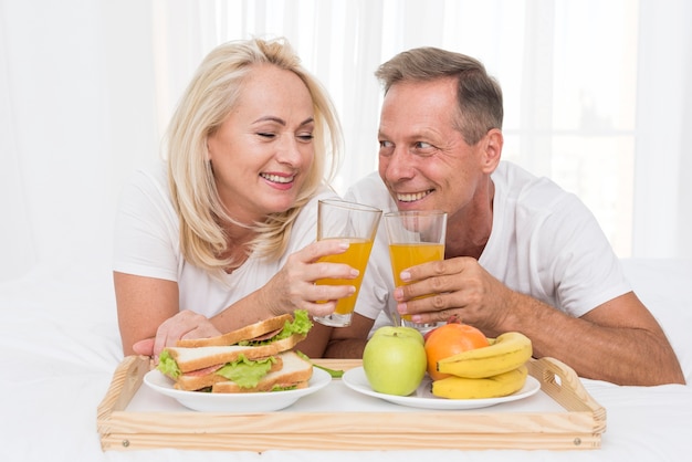 Close-up pareja feliz haciendo un brindis con jugo