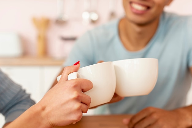 Close-up pareja feliz con tazas de café