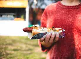 Foto gratuita close-up persona sosteniendo un hot dog