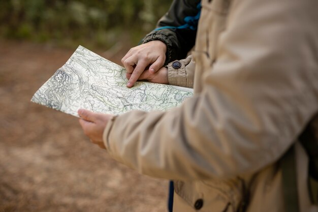 Close-up personas leyendo un mapa al aire libre