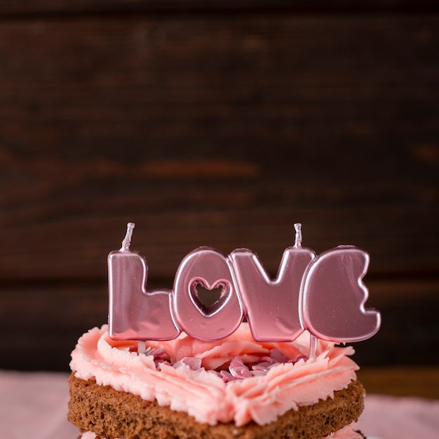 Close-up de rebanada de pastel en forma de corazón con velas