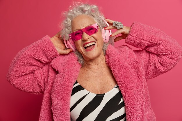 Close Up retrato de abuela de moda arrugada feliz vistiendo abrigo y medias rosa