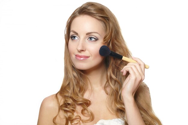 Close-up retrato de joven bella mujer aplicar maquillaje