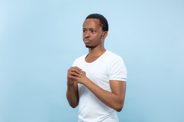 Close up retrato de joven modelo masculino afroamericano en camisa blanca ... Dudas, preguntando, mostrando incertidumbre, reflexivo.