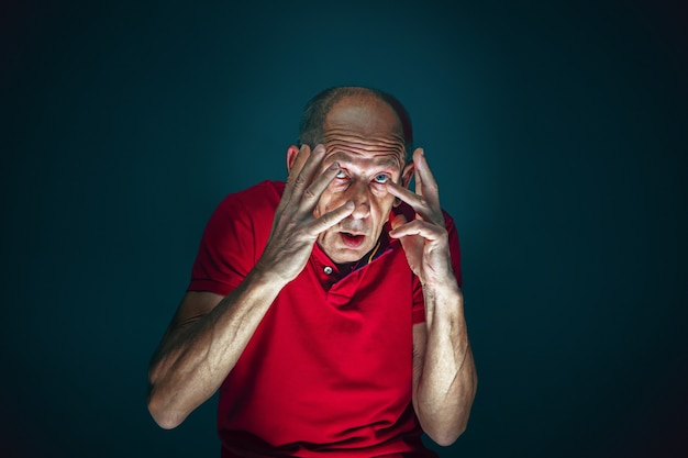 Foto gratuita close up retrato de loco asustado y conmocionado hombre aislado en la oscuridad