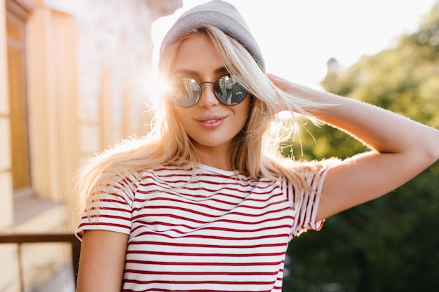 Foto gratuita close-up retrato de mujer bonita rubia disfrutando del sol en la mañana