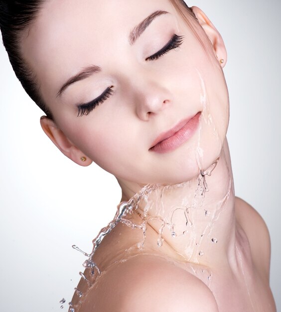 Close-up retrato de mujer joven con gotas de agua en su hermoso rostro