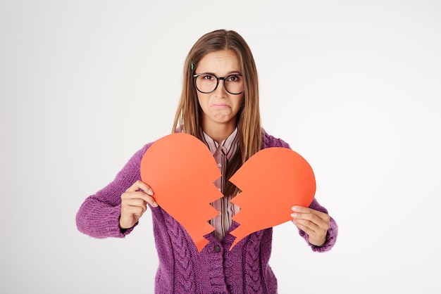 Foto gratuita close up retrato de mujer joven sosteniendo una forma de corazón roto