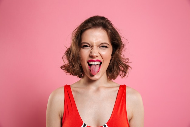 Close-up retrato de mujer morena divertida mostrando lengua