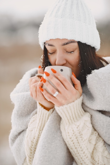 Foto gratuita close-up retrato de mujer en suéter blanco con té