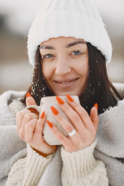 Close-up retrato de mujer en suéter blanco con té