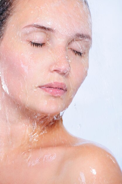 Close-up retrato de rostro femenino joven con salpicaduras y gotas de agua