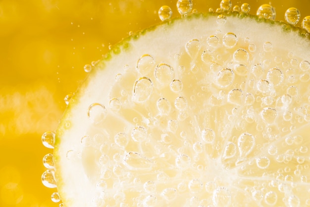 Close-up rodaja de limón con burbujas de agua