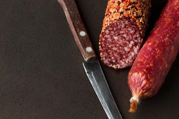 Close-up salami con cuchillo sobre la mesa
