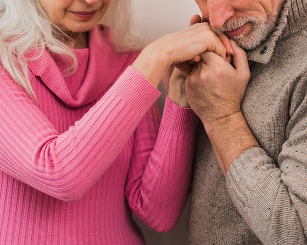 Foto gratuita close-up senior hombre besando a su esposa manos