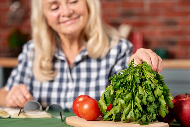 Foto gratuita close-up senior mujer preparando verduras