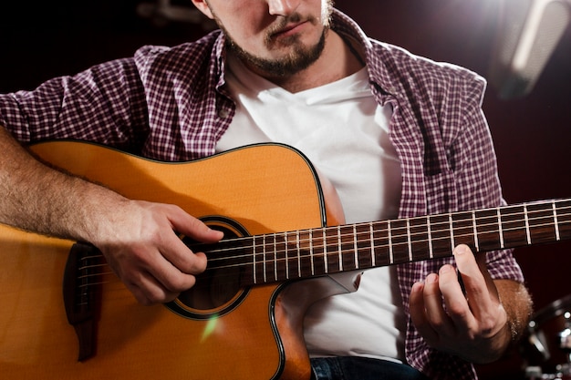 Close-up shot de chico tocando la guitarra