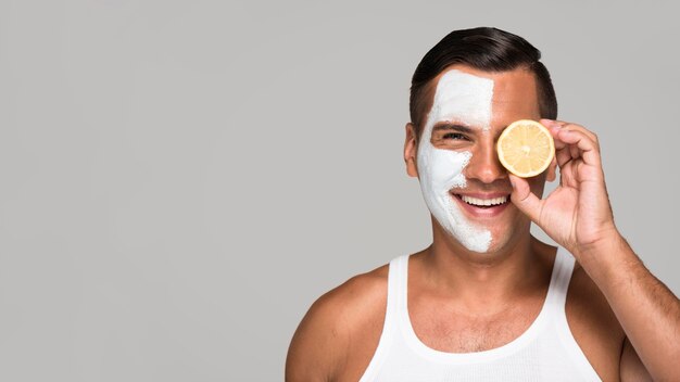 Close-up smiley man holding lemon half