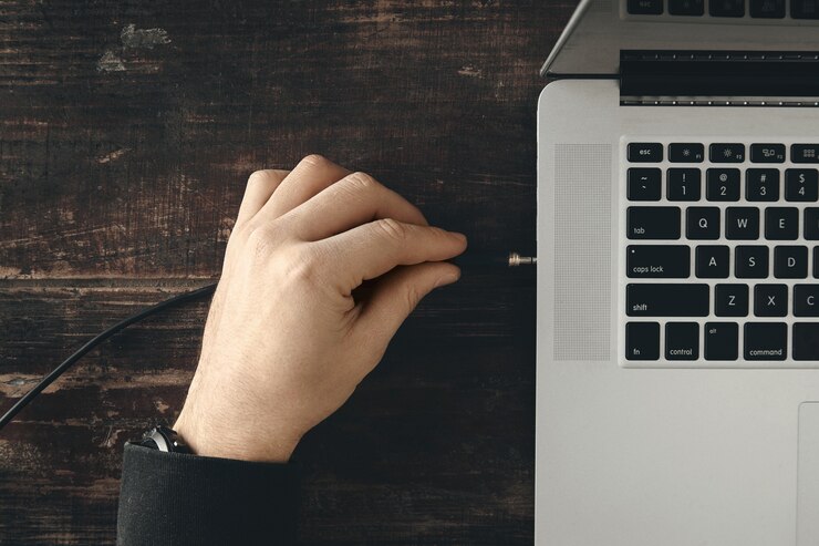 Photo Gratis close up tangan mencolokkan kabel headphone ke port musik jack stereo di laptop retina