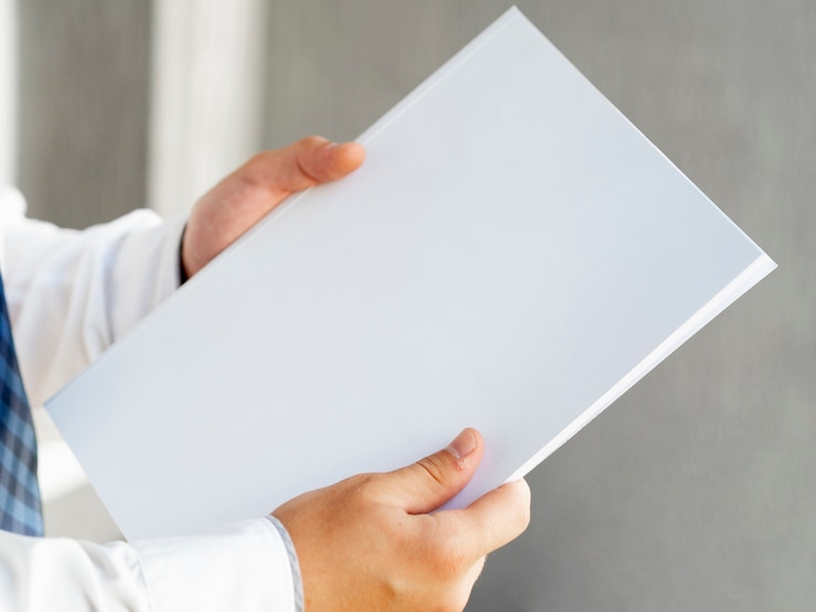 Photo Gratis close-up tangan menunjukkan setumpuk mock-up kertas
