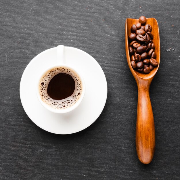 Close-up taza de café con una cucharada de frijoles