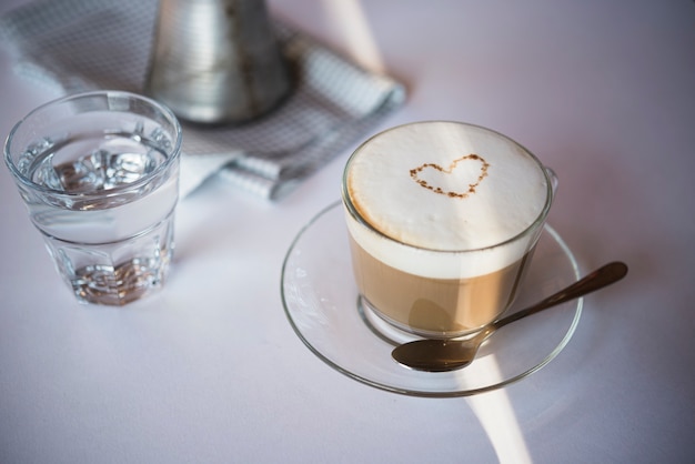 Foto gratuita close-up taza de café con leche con vaso de agua