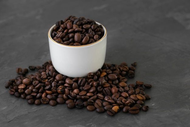 Close-up taza de cerámica llena de granos de café.