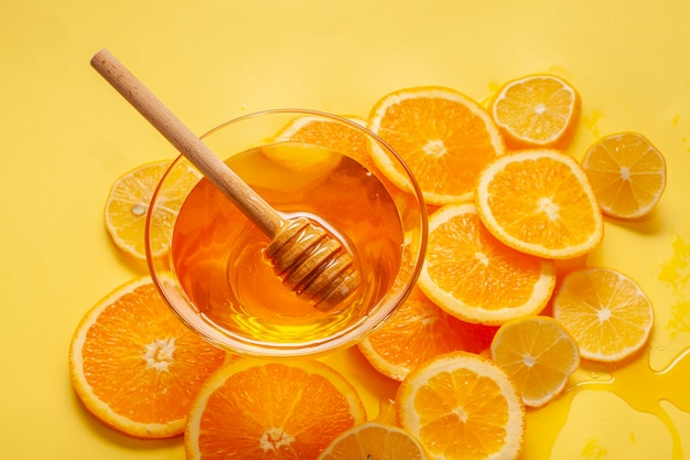 Close-up tazón de miel con rodajas de naranja